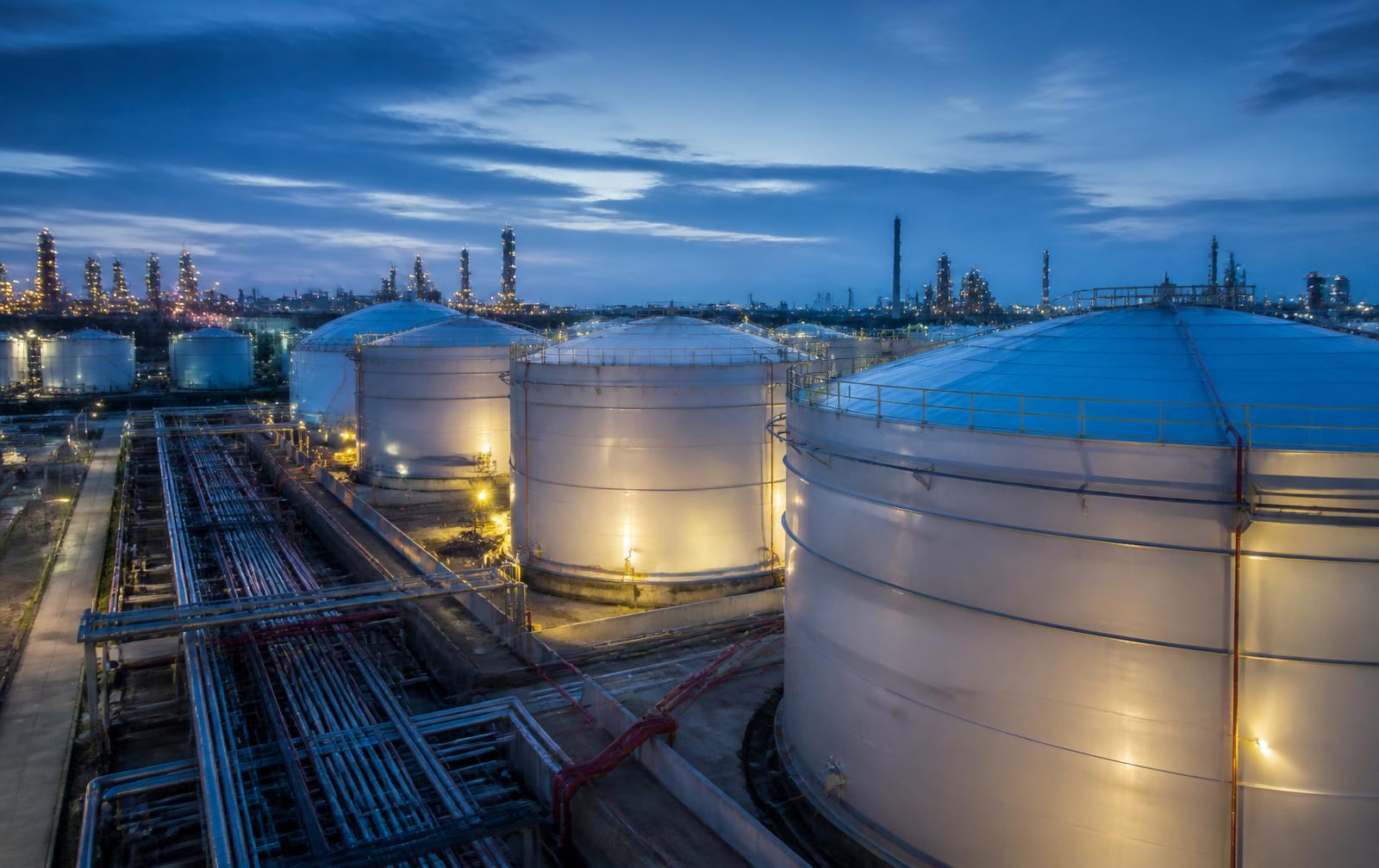 Fuel oil storage tanks and pipework at a refinery terminal at dusk